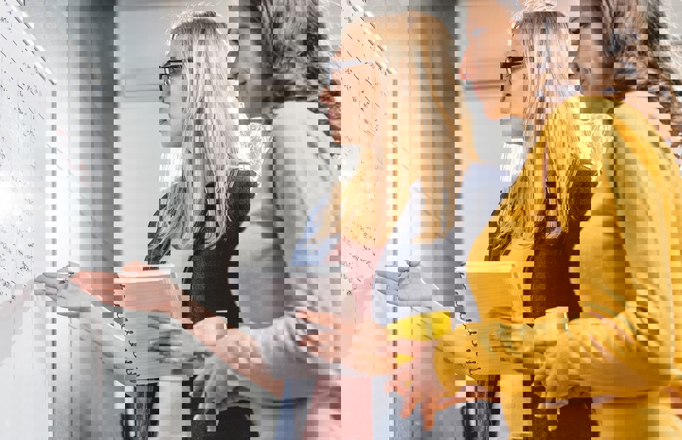 Människor vid tavla som arbetar i Opus, lösningen och systemet för systematiskt arbetsmiljöarbete.